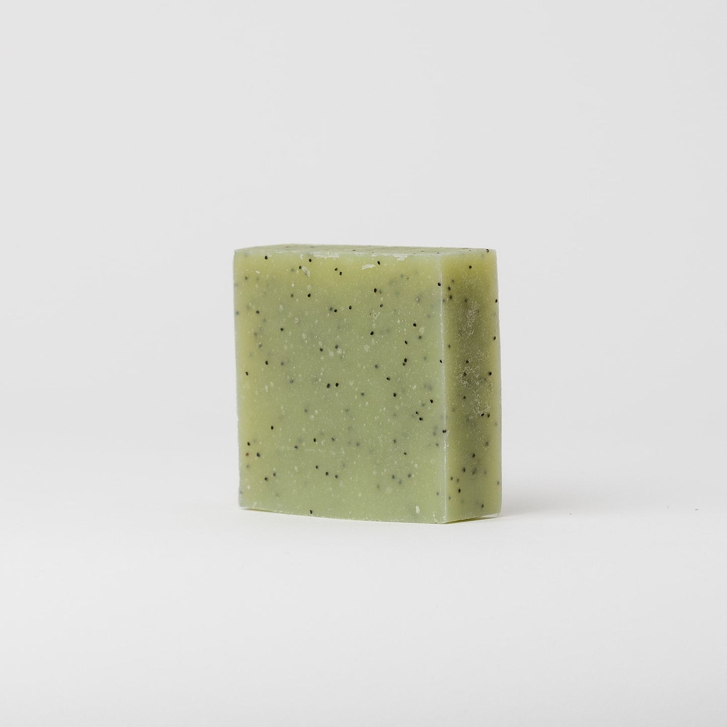 A square bar of My Neighbor’s Tallow Blue Tansy & Raw Honey Tallow Soap with small black specks stands upright on a plain white background.