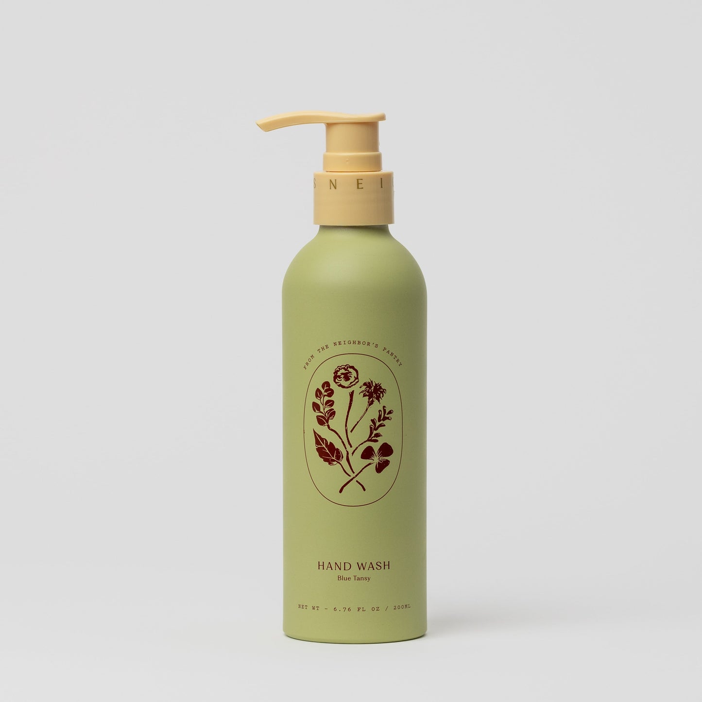 A green bottle of My Neighbor’s Tallow Blue Tansy Hand Wash with a yellow pump and floral label design, displaying "HAND WASH Blue Tansy," set against a plain white background.