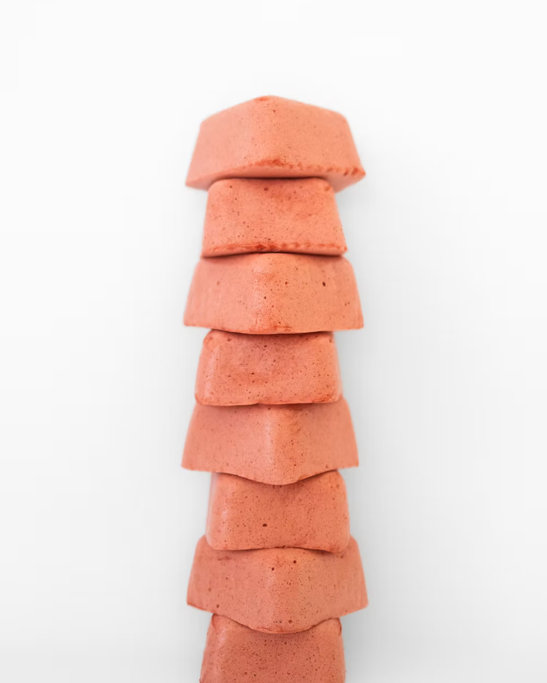 A tall, uneven stack of six Peppermint Super Mallow marshmallows by Super Mallows is arranged against a plain white background.