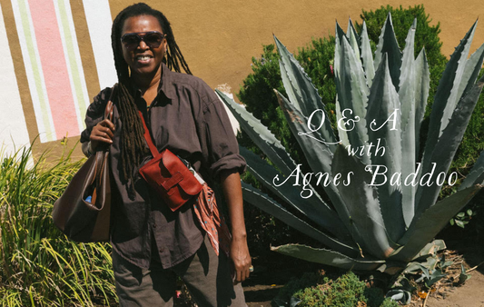 Agnes baddoo standing infront of an agave plant with a few of her leather bags