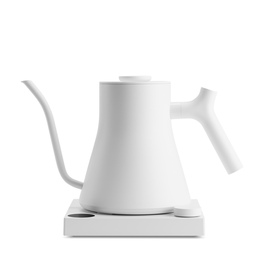 The Stagg EKG Pro Electric Kettle by Fellow Wholesale is a minimalist white pour-over kettle, featuring a slender curved spout and a sleek handle on a square base. With modern elegance and precision temperature control, it is ideal for pouring precise amounts of water, perfect for making pour-over coffee or tea.