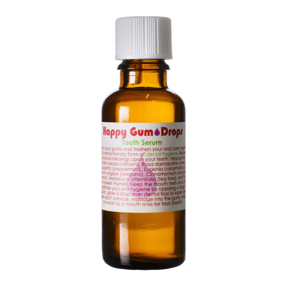 An amber glass bottle labeled "Living Libations Happy Gum Drops" with a white screw cap. The label has red and white text listing natural ingredients and usage instructions. The bottle appears to be designed for dental hygiene, promoting gum health and fresh breath.