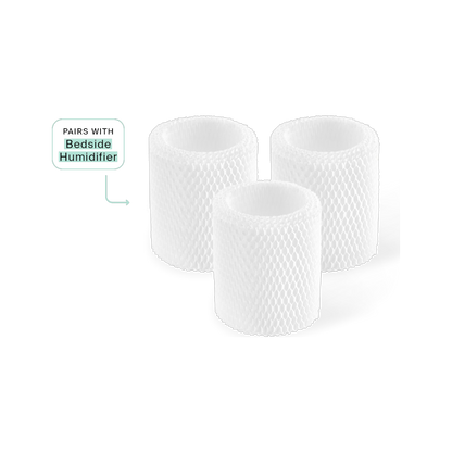 A black background features three white cylindrical mesh filters labeled with an arrow as "Bedside Humidifier," highlighting their anti-microbial properties for a healthier environment. They are the Canopy Bedside Humidifier Filter 3-Pack.