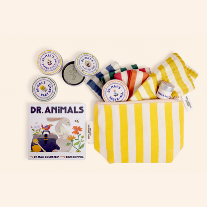 The Dr. Max's New Parent Gift Box features a yellow-and-white striped pouch, striped cloths, diaper ointment tins, a bottle, and the “Dr. Animals” children’s book displayed on a light background.