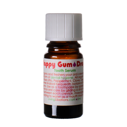A small brown glass bottle labeled "Happy Gum Drops" from Living Libations promotes dental hygiene. The bottle features a white cap and a white label with green and red text detailing usage instructions. Using natural ingredients such as peppermint and clove oil, this 5ml product ensures your teeth stay fresh and healthy.