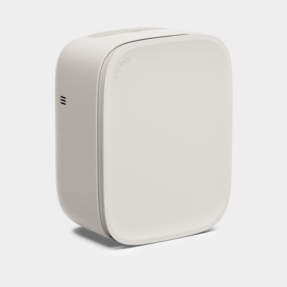 Cream A minimalist, Bedside Air Purifier by Canopy stands upright with rounded edges and subtle side vents against a light background, featuring the brand name "Canopy" faintly on the top front edge.