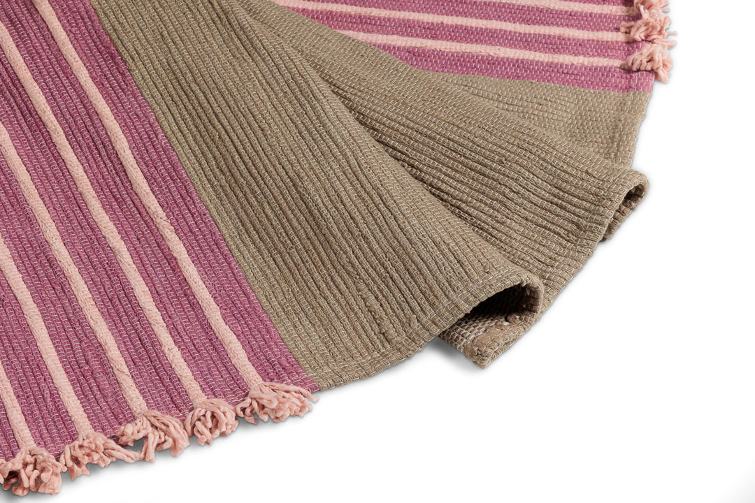 Close-up of a textured ribbed fabric in pink and olive green stripes, resembling the Bennd Yoga Dark Harda and Sappan Wood Ayurvedic Yoga Mat. This fabric also has tasseled edges, echoing the aesthetic achieved with Sappan Wood coloring.