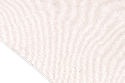 A close-up shows the textured beige fabric crafted from organic cotton on the right, set against a contrasting black background on the left, echoing the timeless design of Bennd Yoga's Indigo Ayurvedic Yoga Mat.