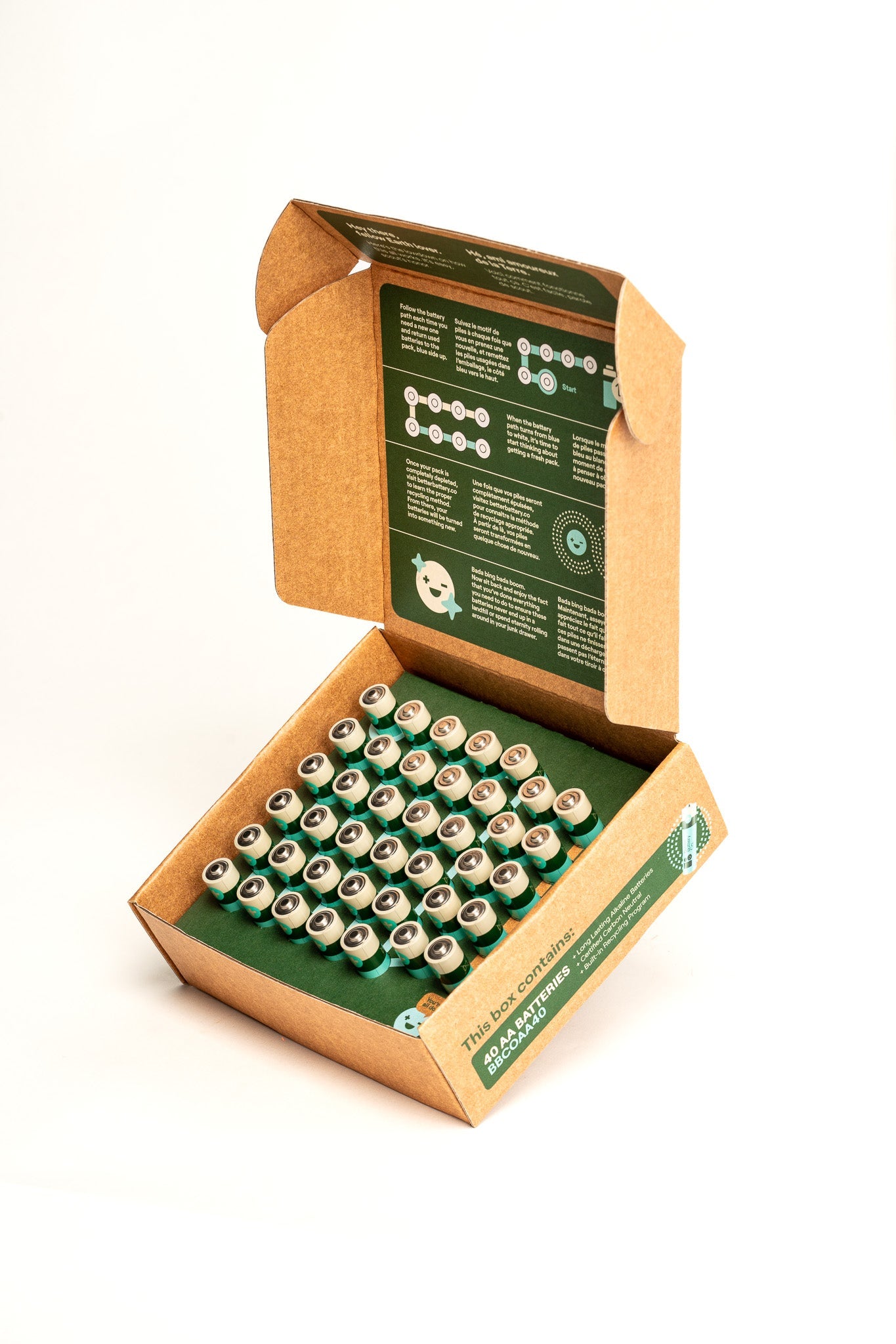 The Better Battery Co. AA 40 Pack comes in an open cardboard box containing a grid of 40 silver and green AA alkaline batteries. The inside lid is printed with instructions and graphics providing guidelines or information. The packaging is designed to be eco-friendly, focusing on sustainability and ensuring it's fully recyclable.