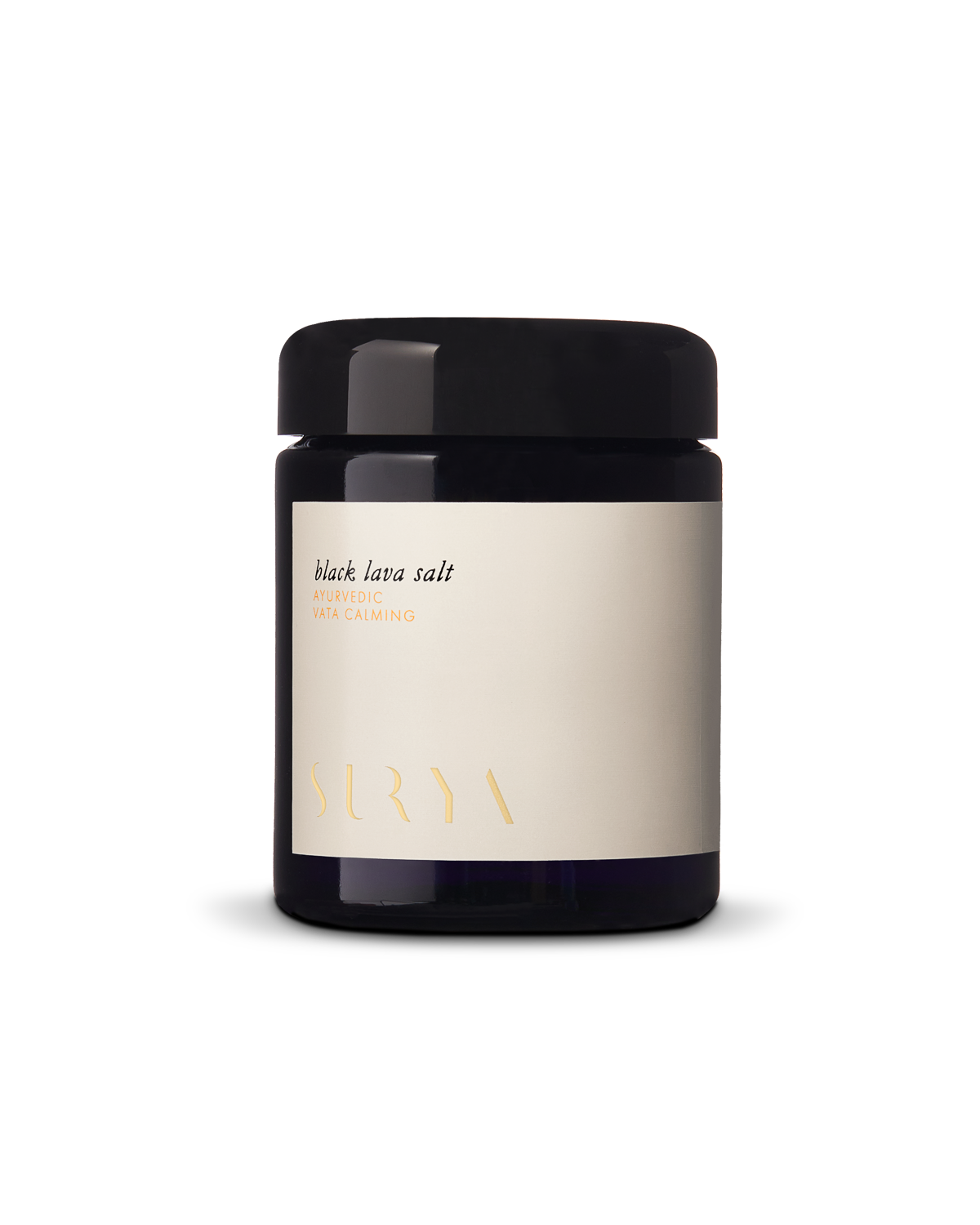 A black cylindrical jar features a dark blue glass body topped with a black lid. The label, displaying "Black Lava Salt - AYURVEDIC - VATA CALMING" in simple font, is accompanied by the brand name "Surya" at the bottom.