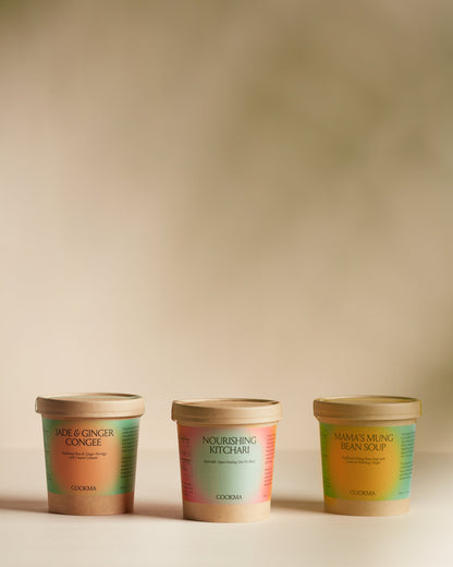 The Cookma Healing Bundle—featuring three tubs of nourishing foods—is displayed side by side against a softly lit, neutral background, ideal for immune support or surgery recovery.