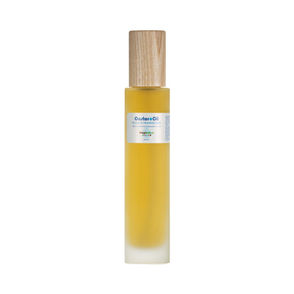 Living Libations' Castor Oil + Occulta Frankincense comes in a tall, slender bottle with a wooden cap. It contains rich ricinoleic acids for optimal skin conditioning. The yellow oil fills the bottle, which features a white label with delicate floral graphics and slightly blurred text.