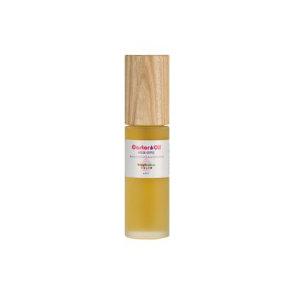 The product is a glass bottle with a wooden cap containing Living Libations' Castor Oil + Rose Otto. It features a white label with red text emphasizing its rich ricinoleic acids for nourishing benefits.
