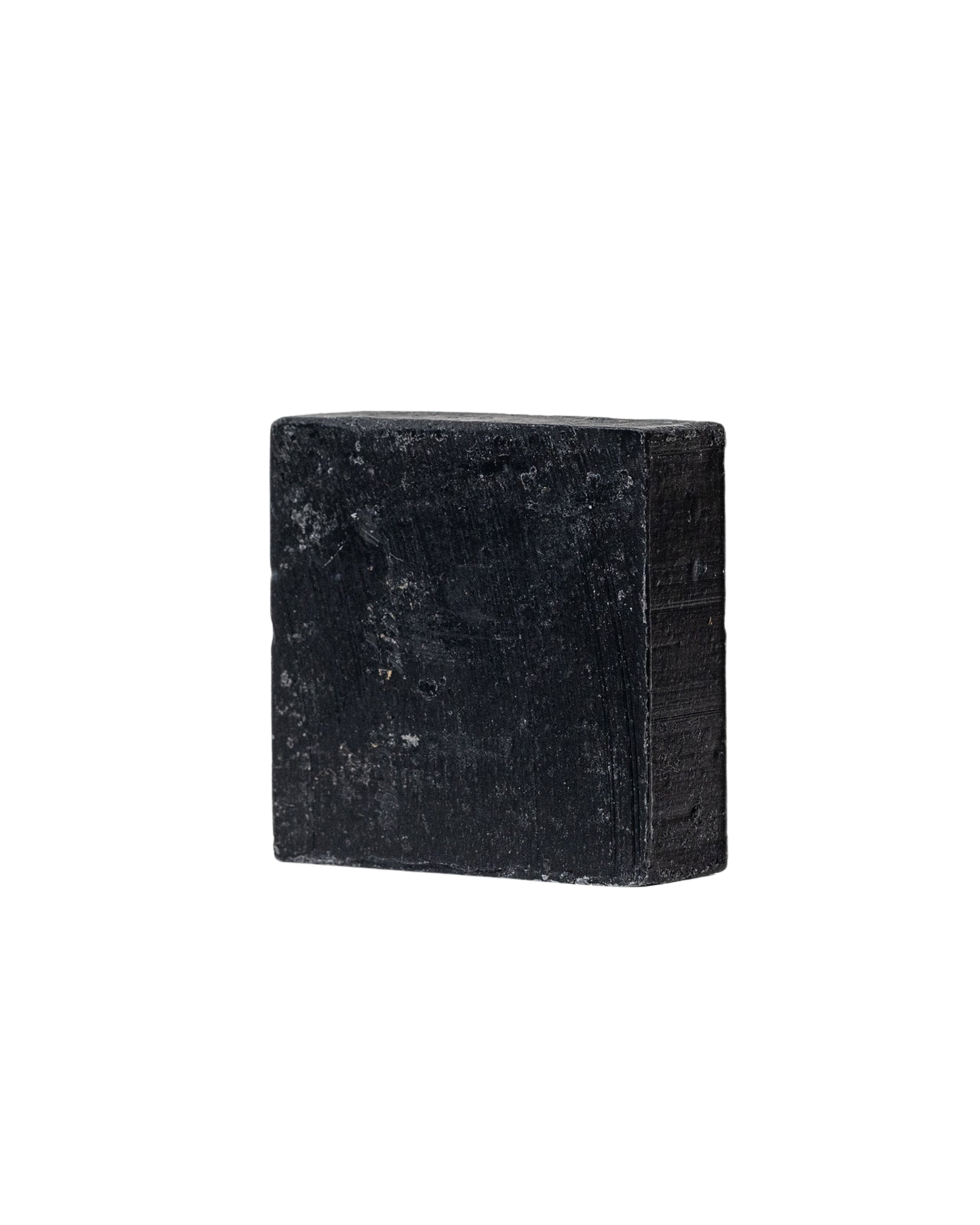 A rectangular black bar of Charcoal Tallow Soap by My Neighbor’s Tallow, featuring a rough, matte texture, is displayed against a plain white background.