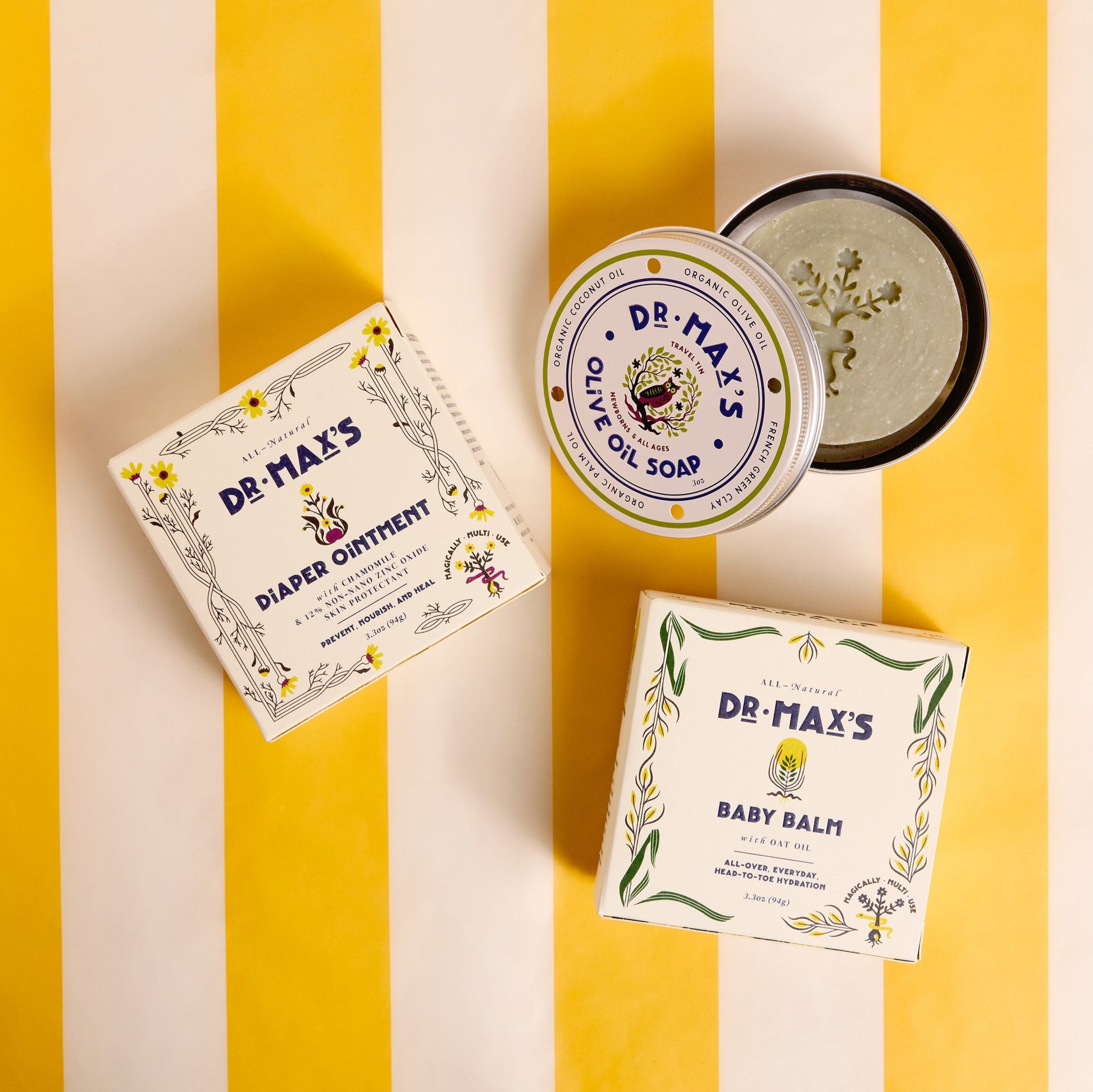 Three Dr. Max’s Baby Essentials Bundle products are arranged on a yellow and white striped background.