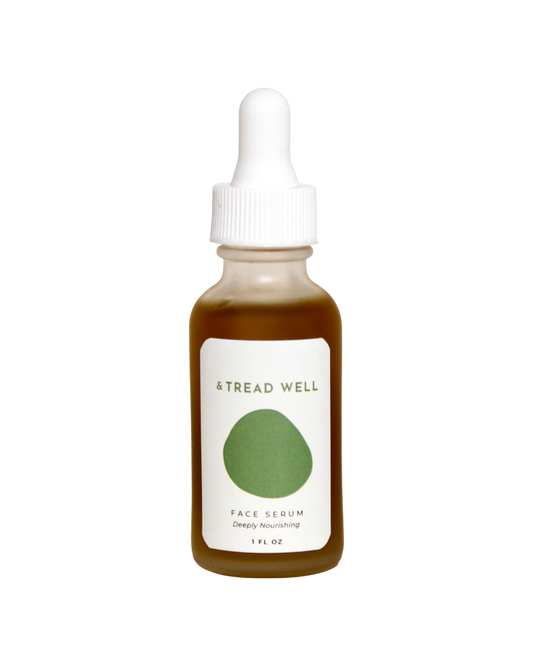 A brown glass dropper bottle labeled "& Tread Well Face Serum" with a green oval design and white cap. This 1 fl oz natural serum is deeply nourishing and hydrating.