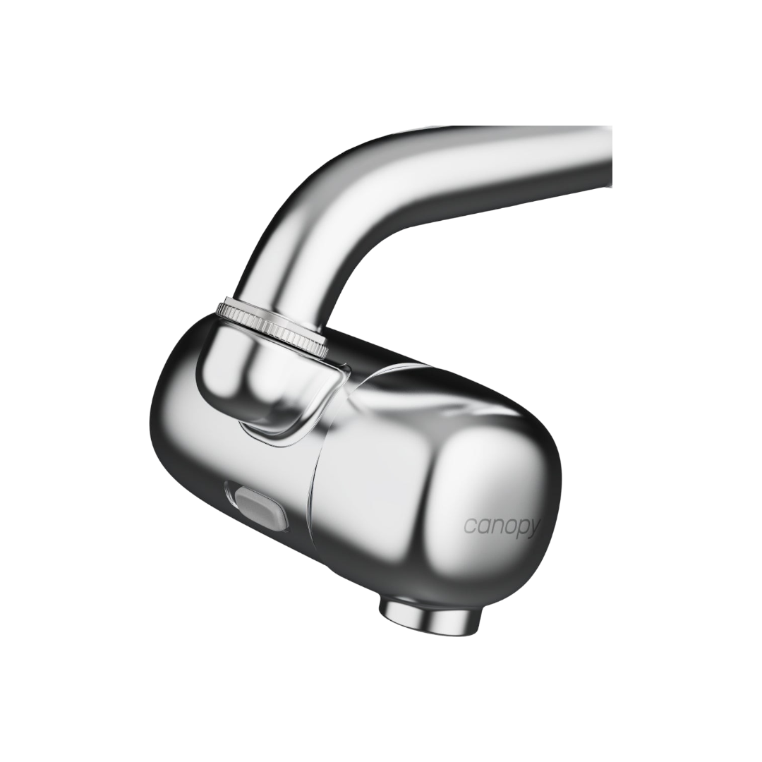 A close-up of the Canopy Faucet Filter shows its modern, rounded chrome design with a side button, attached to a faucet. The Canopy filter delivers cleaner water for a healthy lifestyle.