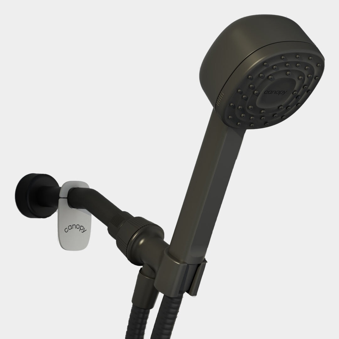 The Canopy Handheld Filtered Showerhead in matte black, featuring a hose and wall-mounted bracket, offers a refreshing bathing experience against a white background.