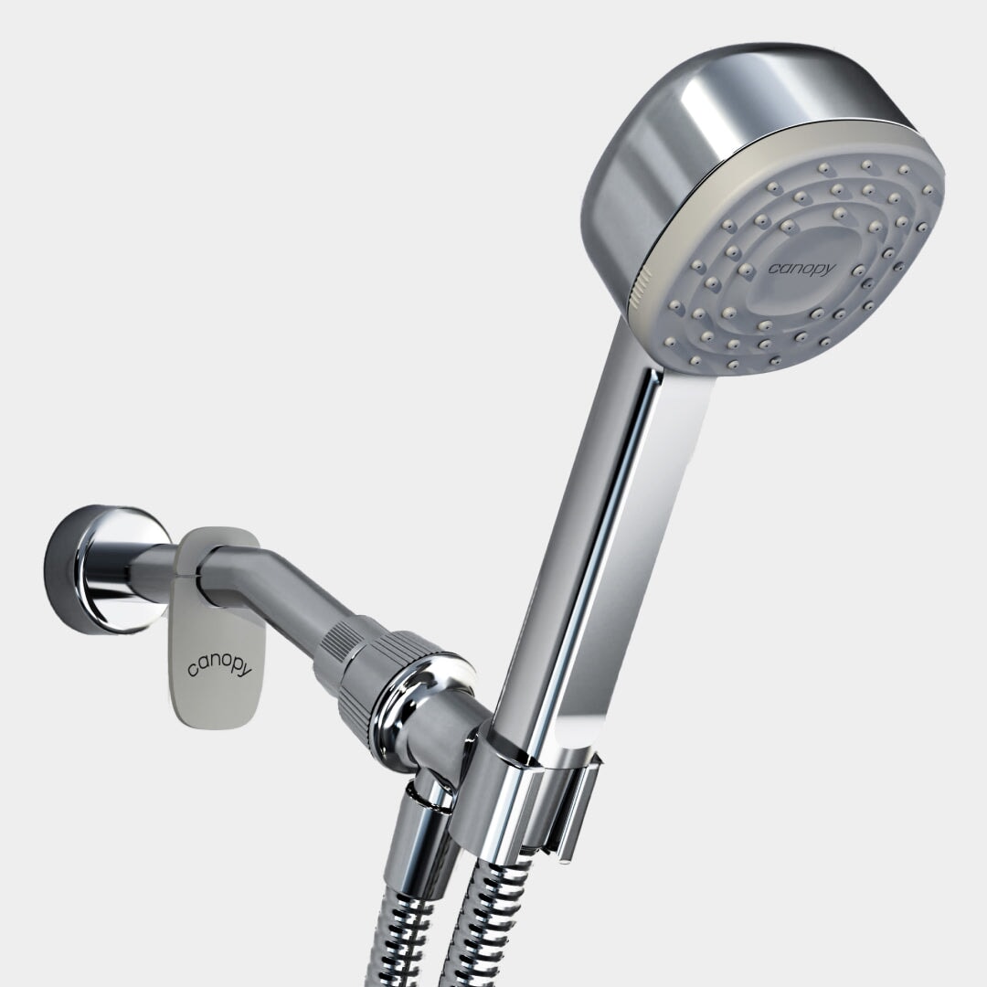 A close-up of the Canopy Handheld Filtered Showerhead shows it mounted on a wall bracket with a flexible hose. Multiple spray nozzles deliver a fresh and revitalizing shower experience.