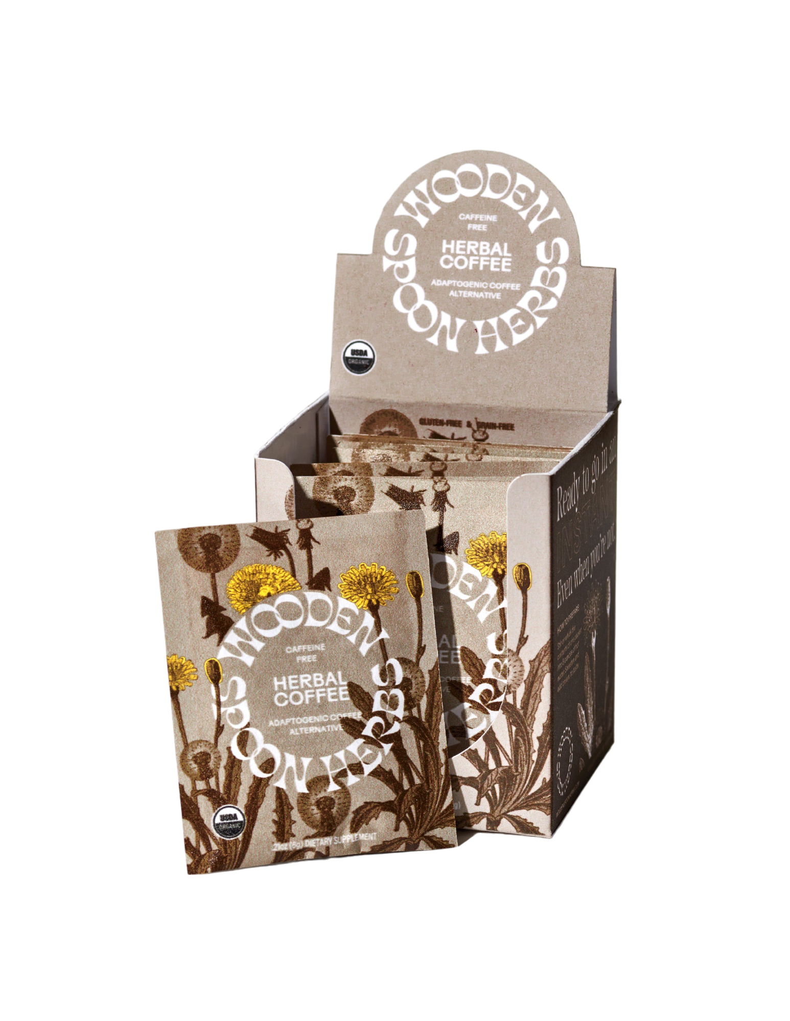A product display box of WOODEN SPOON HERBS Herbal Coffee, highlighting a caffeine-free blend with multiple individual packets. The packaging features illustrations of dandelion and other plants in a natural earthy color scheme, with text indicating USDA organic certification and the inclusion of adaptogenic mushrooms.