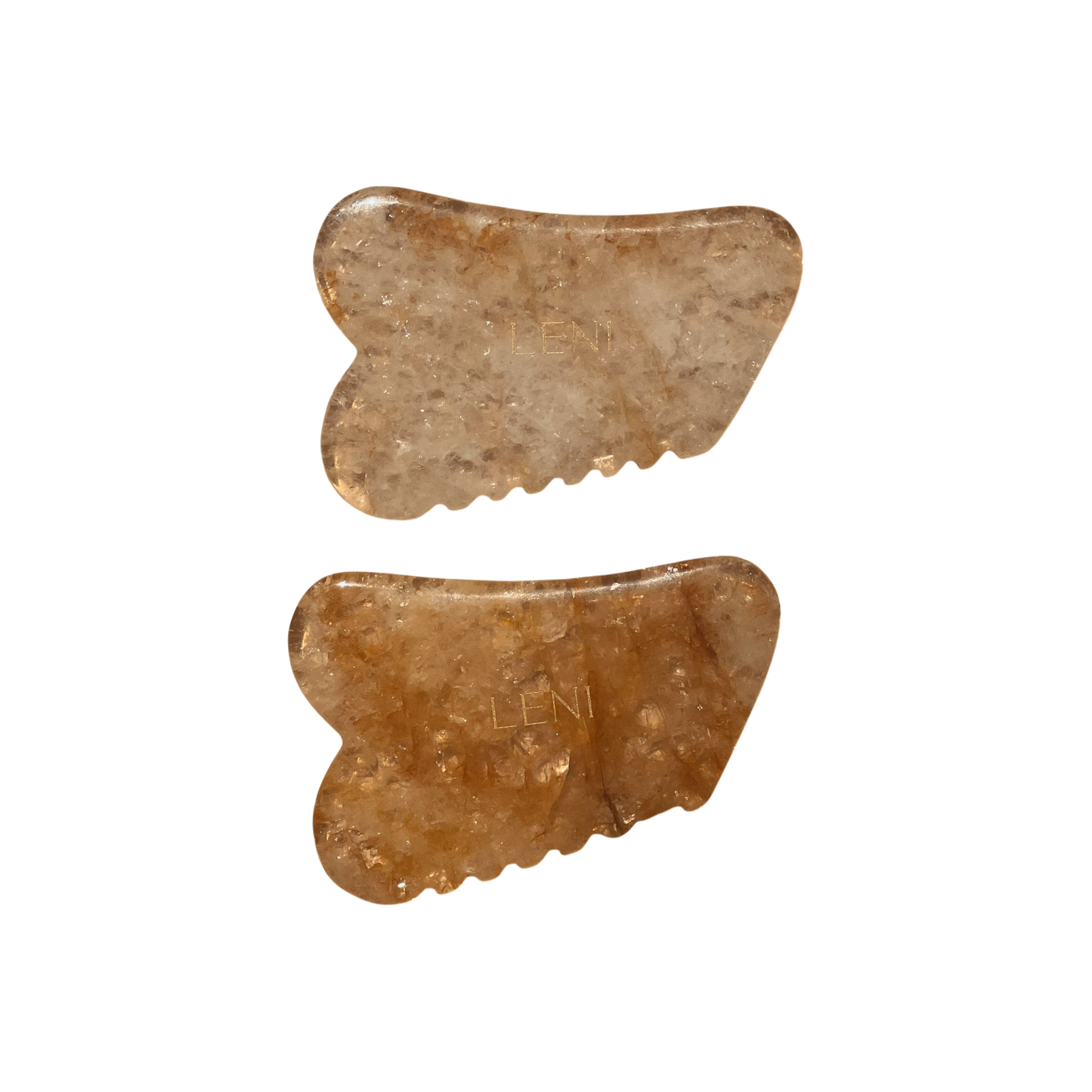 Two brownish, translucent THE GUASHA TOOL by LENI with wavy edges stand vertically on a white background. Each tool is engraved "LENI," perfect for facial massage and boosting lymphatic drainage.
