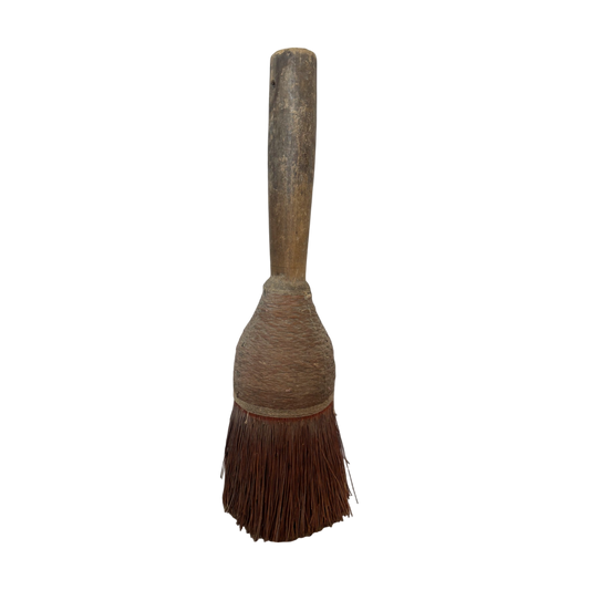 The Antique Hearth Brush I by Shoppe Maison features a vintage wood handle with coarse, sturdy bristles, likely used for cleaning or dusting. The handle displays signs of wear and age, while the overall design is simple and rustic against a black background.