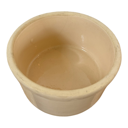 A Vintage Medium Stoneware Crock from Shoppe Maison, featuring an off-white, round design with a wide open top and smooth interior surface. The crock is empty, displaying a slightly glossy finish inside. Its matte exterior gives it a simple, rustic appearance reminiscent of vintage homeware.