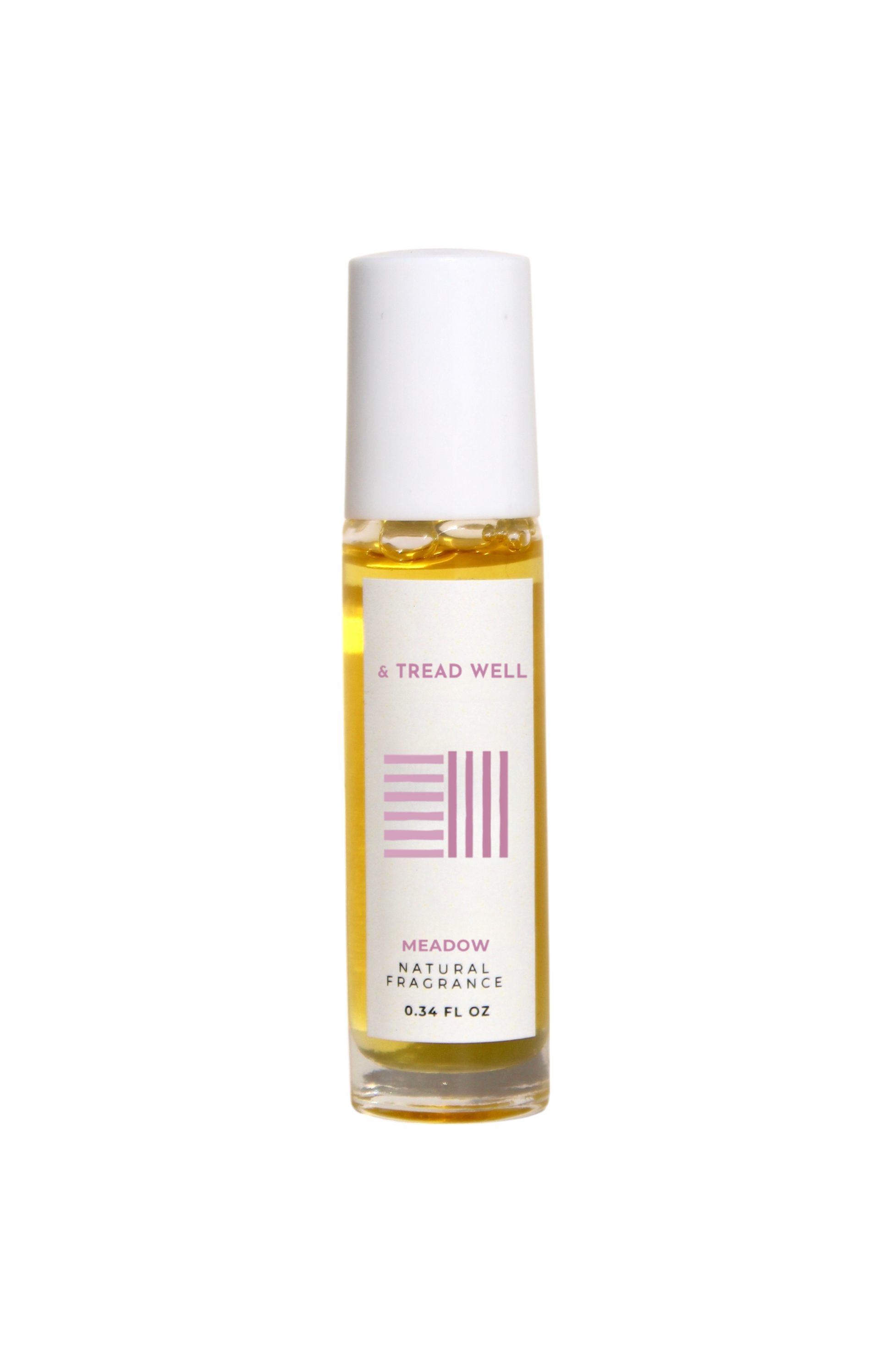 A small glass bottle of & Tread Well Natural Fragrance – Meadow, an organic floral perfume with a white cap and pink-and-black label, containing yellow liquid. This Hudson Valley roll-on is handcrafted, elegant, and natural.