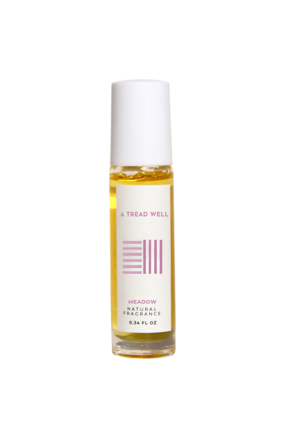 A small glass bottle of & Tread Well Natural Fragrance – Meadow, an organic floral perfume with a white cap and pink-and-black label, containing yellow liquid. This Hudson Valley roll-on is handcrafted, elegant, and natural.