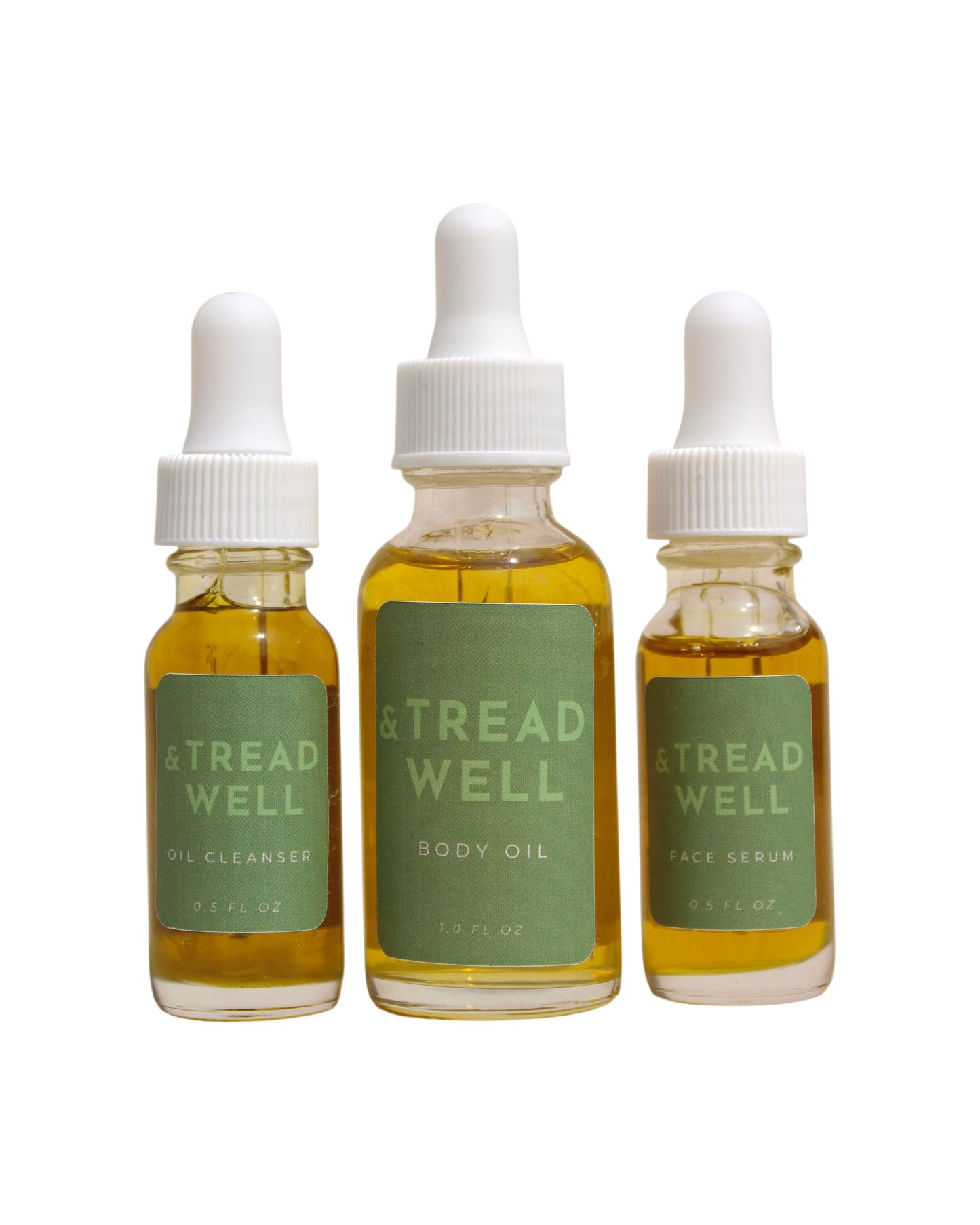 The & Tread Well Mini Essentials set features three travel-size skincare products—Oil Cleanser, Body Oil, and Face Serum—in clear bottles with green labels and white dropper caps, each containing yellow liquid.