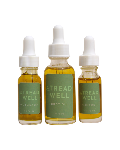 The & Tread Well Mini Essentials set features three travel-size skincare products—Oil Cleanser, Body Oil, and Face Serum—in clear bottles with green labels and white dropper caps, each containing yellow liquid.