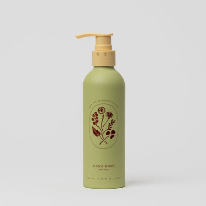 A green bottle of My Neighbor’s Tallow Blue Tansy Hand Wash with a yellow pump and floral label design, displaying "HAND WASH Blue Tansy," set against a plain white background.