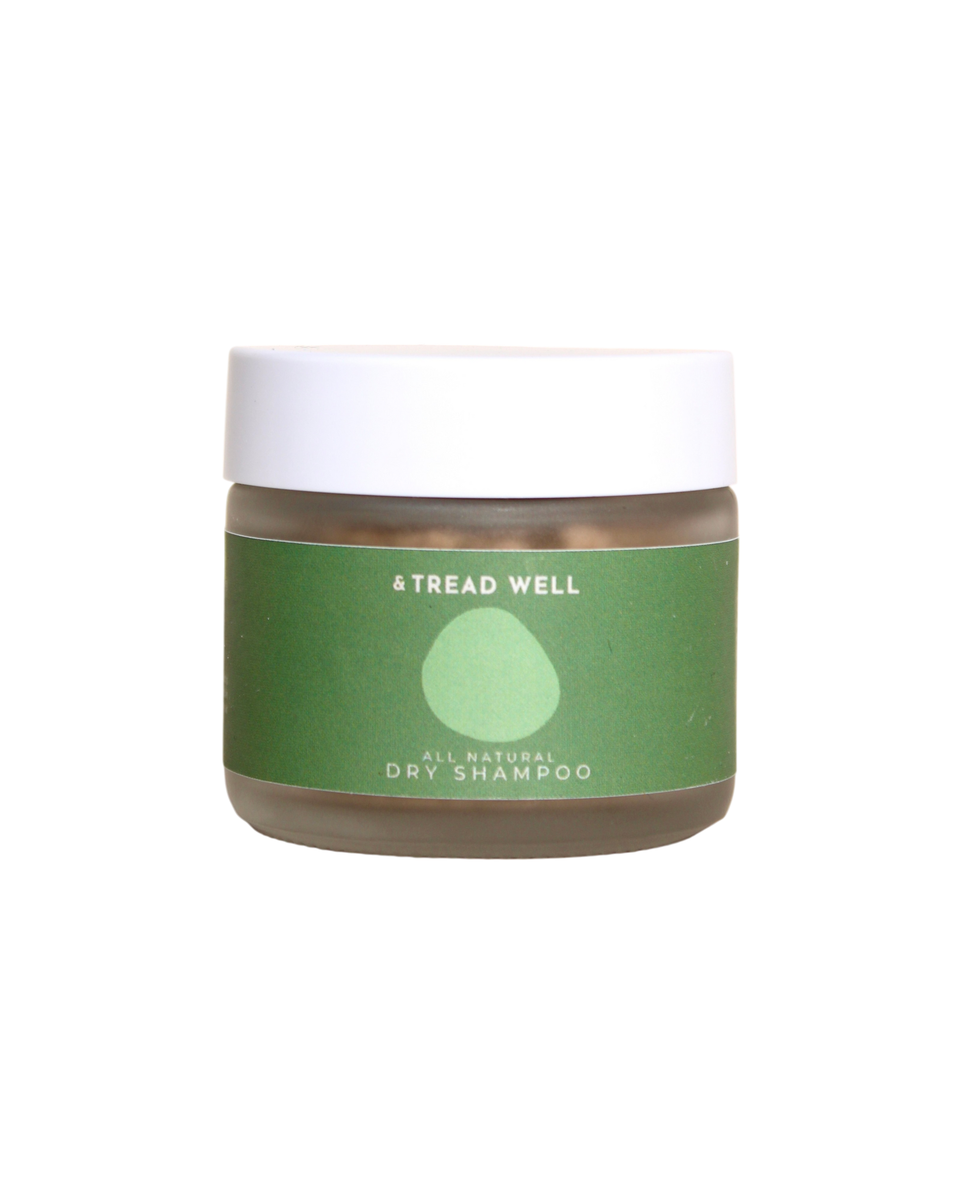 A small clear jar with a white lid and a green label reading "& Tread Well Dry Shampoo." This non-aerosol, plant-based hair powder from & Tread Well features a simple leaf or droplet graphic on its packaging.
