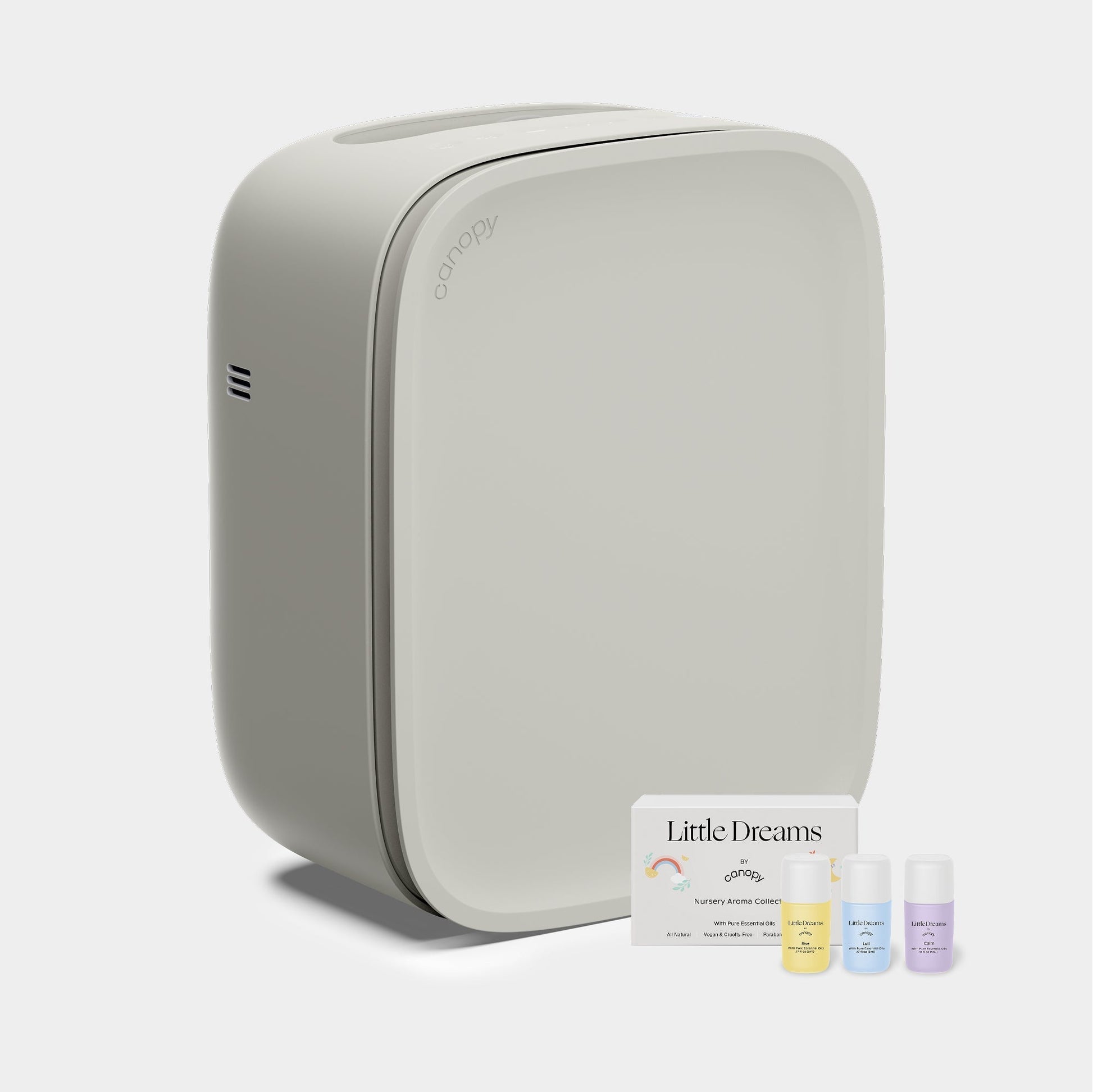 Moonstruck A sleek, modern Canopy Nursery Air Purifier with rounded edges sits beside three small bottles of scented oils and a card labeled "Little Dreams Nursery Aroma Kit" against a plain light gray background.
