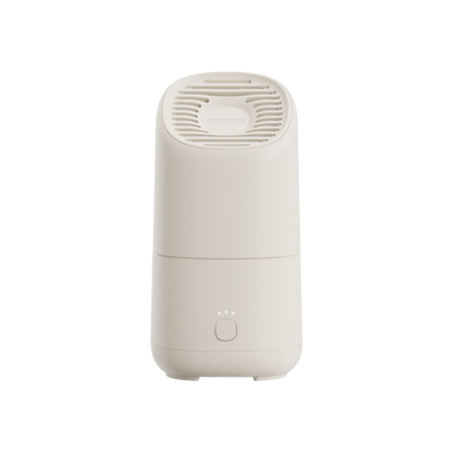 The Canopy Portable Humidifier is a modern, white, cylindrical device with a vented top and a front circular button featuring three indicator lights, shown against a plain white background.