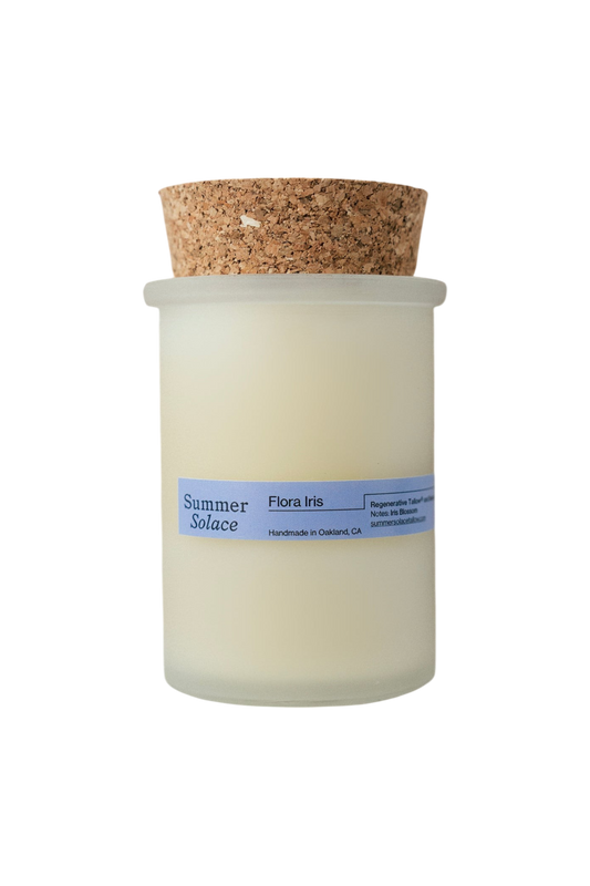 The Flora Iris Candle - Regenerative Tallow® by Summer Solace Tallow is a handmade, pale cream tallow candle in a frosted glass jar with cork lid, featuring a soft iris scent and crafted in Oakland, CA.