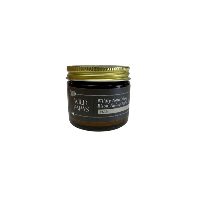 A small amber glass jar with a gold lid labeled "Wildly Nourishing Bison Tallow Balm - Man" by Wild Mamas features regenerative bison tallow, creating a premium men's balm, shown on a plain white background.
