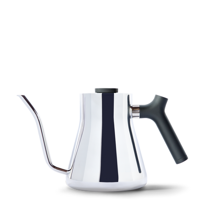The Stagg Pour-Over Kettle from Fellow Wholesale features a sleek, modern design with a stainless steel gooseneck and a shiny finish. It includes a black counterbalanced handle for ease of use and a precision pour spout for controlled pouring. The minimalist aesthetic is complemented by its integrated brew-range thermometer, all set against a plain white background.