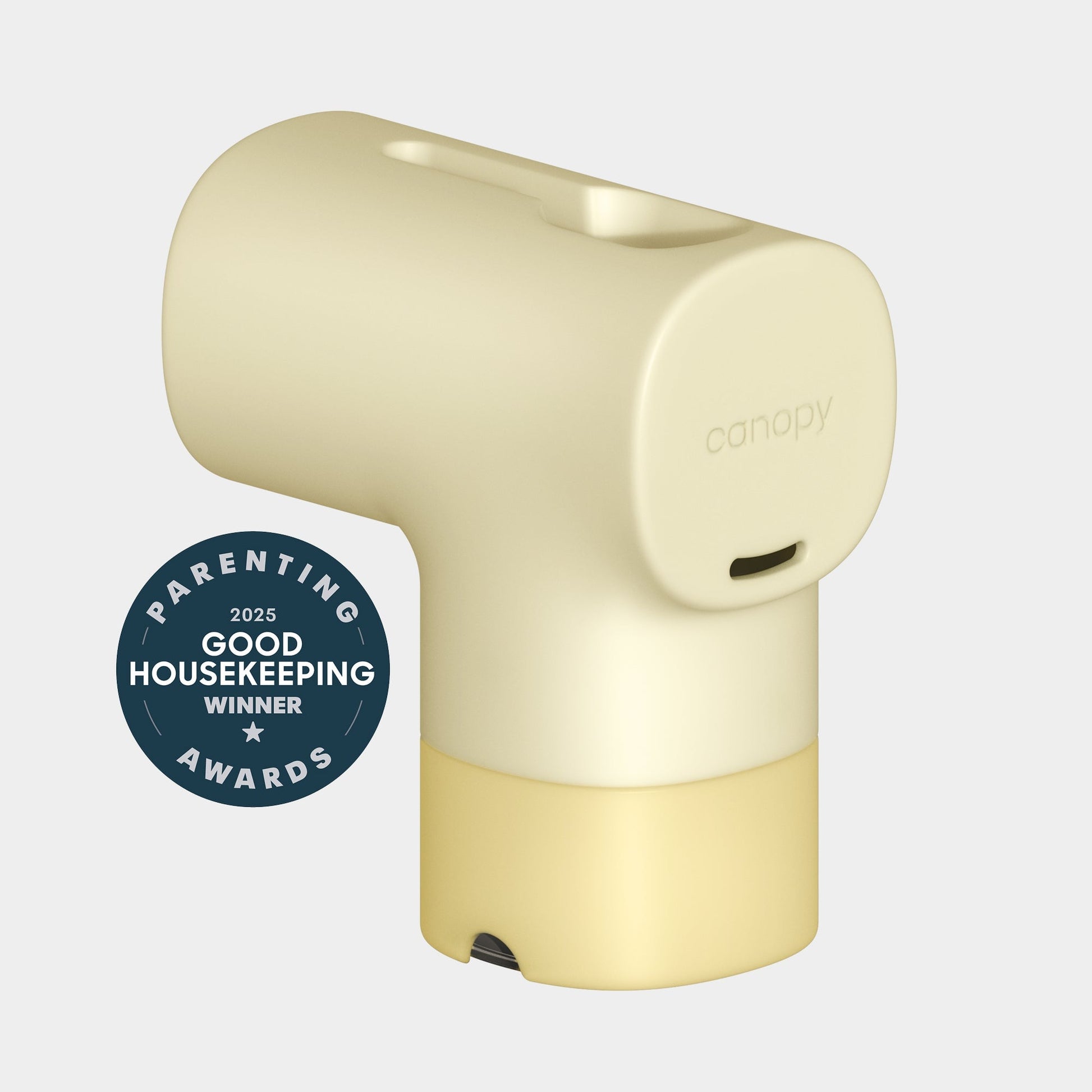 A light yellow, modern Canopy Bath Tub Filter with a rounded design sits beside a blue "2025 Good Housekeeping Winner—Parenting Awards" badge on a plain light background. Fulfilled by Canopy.
