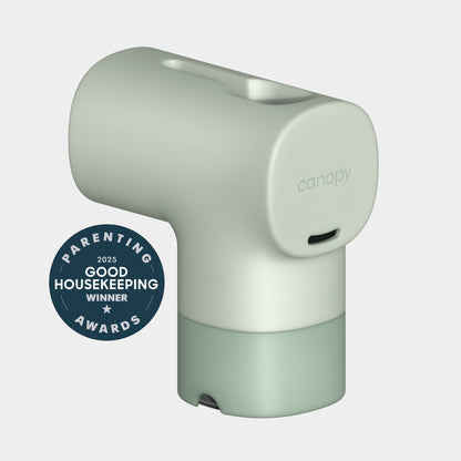 A minimalist, pale green Canopy Bath Tub Filter with a round top and flat base is shown beside a "2025 Good Housekeeping Parenting Awards Winner" badge on a plain light background.