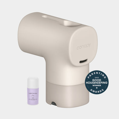 Oat A Canopy Baby Bath Tub Filter sits beside a small bottle of  Dreams Calm scent, with a 2025 Parenting Good Housekeeping Awards winner badge displayed on the right.