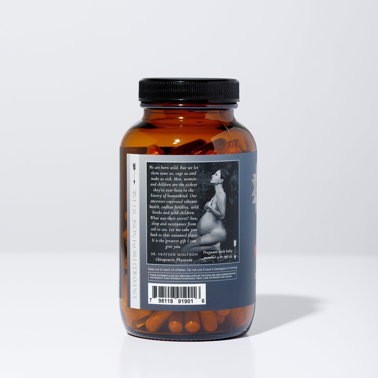 A brown WildMamas Wild Salmon Roe pill bottle with a black cap sits on a white background. The label shows a grayscale pregnant woman, barcode, and Omega-3 superfood benefits. Capsules are visible inside the bottle.