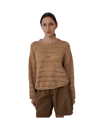 A person with long hair wears the Wol Hide Open Pullover in Tannin with matching shorts. They stand against a plain white background, facing forward with a neutral expression.