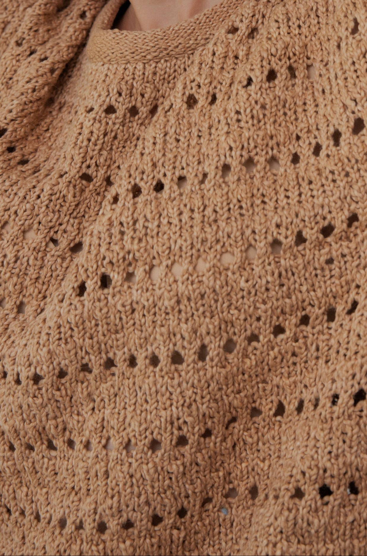 Close-up of Wol Hide's Open Pullover in Tannin, crafted with a textured pattern and small holes. Made from organic cotton, it appears soft and slightly chunky, showcasing intricate handiwork.