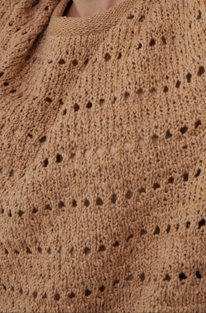 Close-up of Wol Hide's Open Pullover in Tannin, crafted with a textured pattern and small holes. Made from organic cotton, it appears soft and slightly chunky, showcasing intricate handiwork.