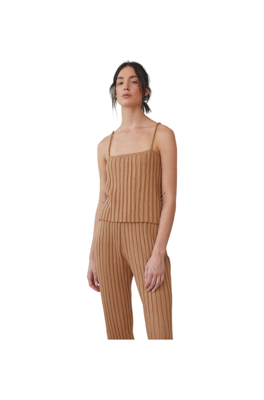 A person wears the Wol Hide Organic Cotton Rib Cami in Toffee, featuring braided straps and paired with matching pants, set against a plain backdrop.