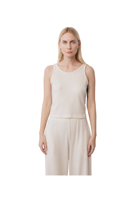 A woman with long blonde hair wears the Wol Hide Wool Tank in Natural, styled with matching wide-leg pants and standing against a plain white background.