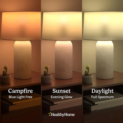 Three images display a Circadian Lightbulb on a wooden table with a cactus, featuring 3 color temperatures: "Campfire" (warm light), "Sunset" (neutral light), and "Daylight" (natural daylight). Text reads: The Healthy Home Shop.