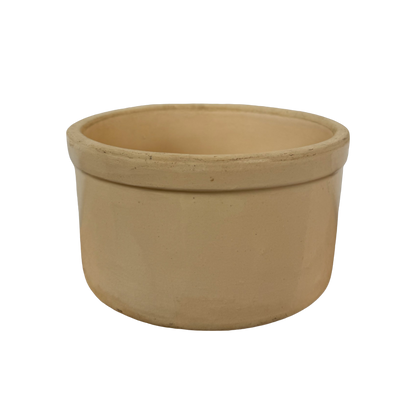 The Vintage Medium Stoneware Crock by Shoppe Maison features a smooth, round shape that is slightly wider at the top than the bottom. Its plain exterior boasts a natural, earthy beige color without any decorative elements, reminiscent of classic vintage homeware. The pot stands out clearly against a completely black background.