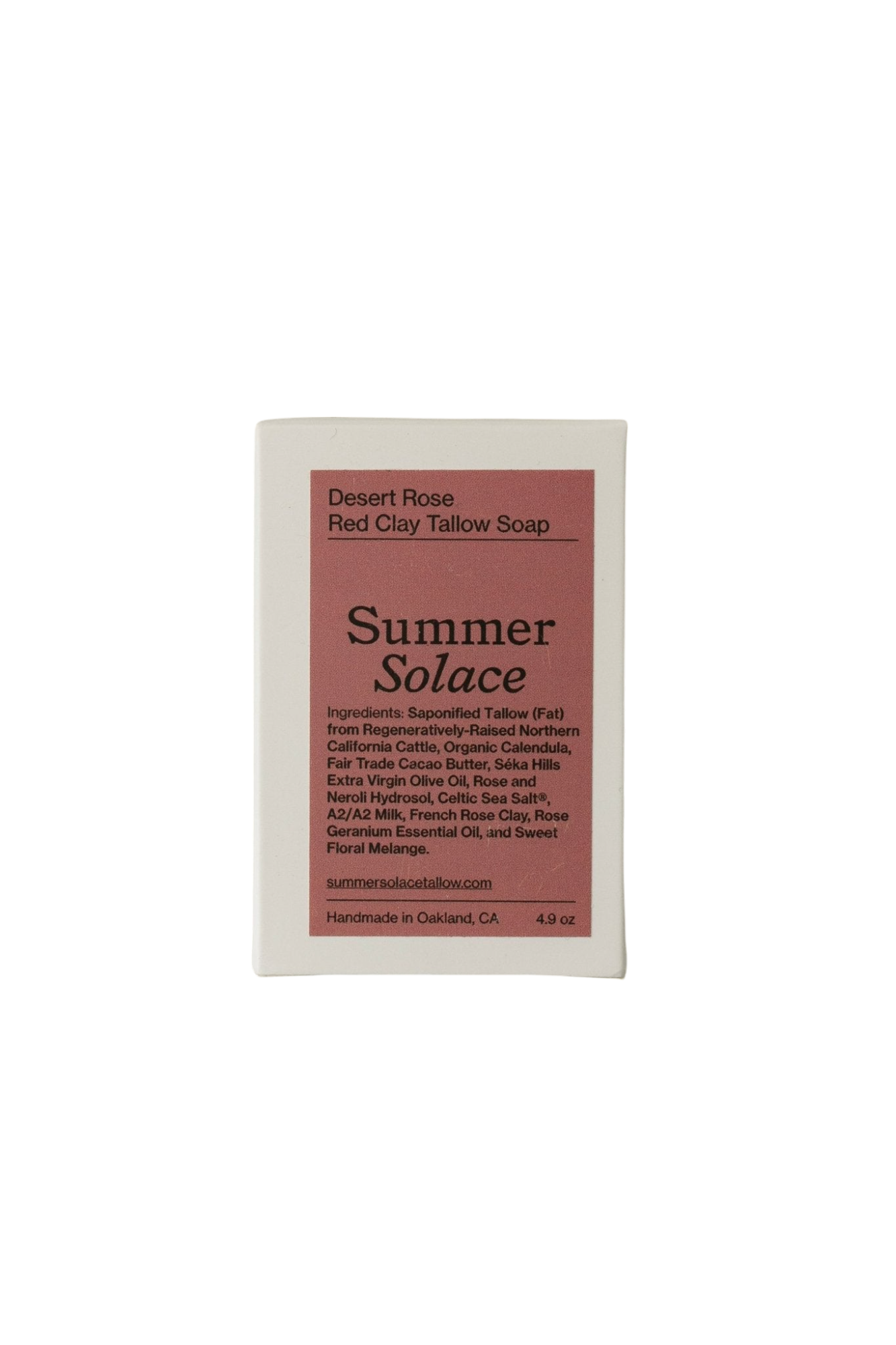A rectangular bar of soap with a pink and white label reads "Desert Rose Red Clay Bar Soap - Regenerative Tallow™ by Summer Solace Tallow." The label lists ingredients such as hydrating tallow, cacao butter, various oils, botanicals, and rose essential oil. Handmade in Oakland, California, the soap weighs 4.9 oz.